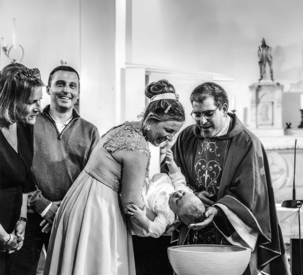 Bébé tenu pendant son baptême à l'église