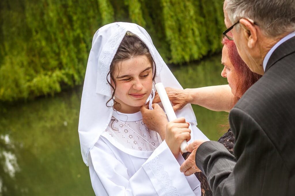 Portrait d’une jeune communiante portant une aube blanche