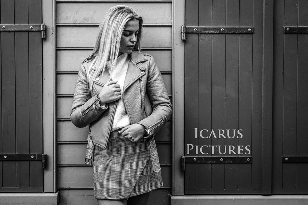 jeune femme en veste cuir contre le devant d'une fenêtre